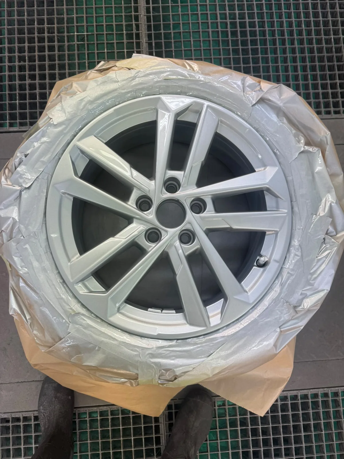 Vers gespoten lichtmetalen velg afgeplakt in de spuitcabine